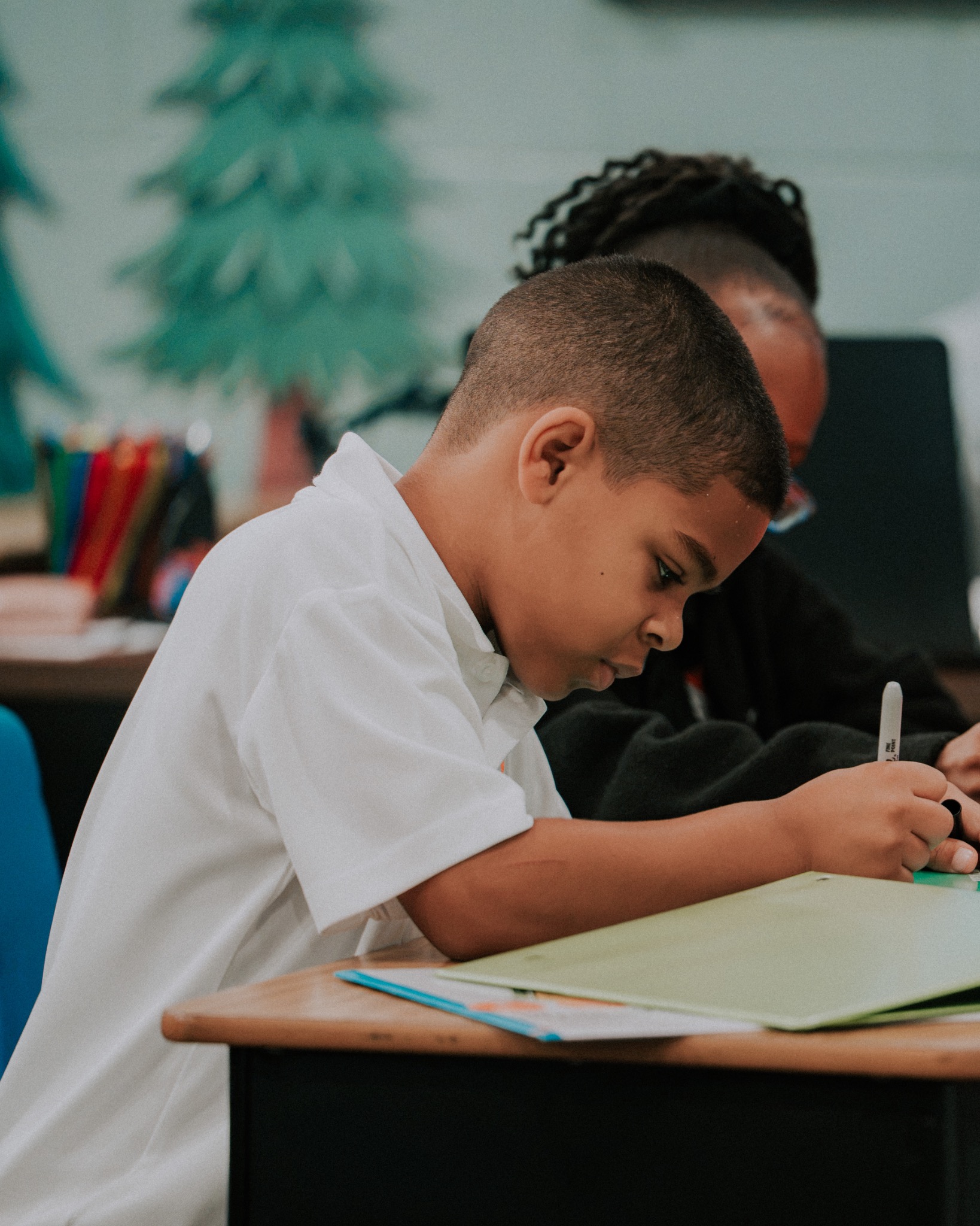 A Destiny Christian School student focused on a classroom writing activity
