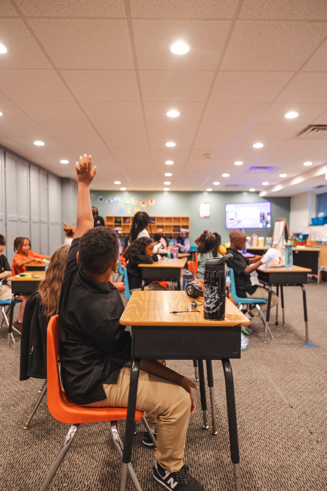 A Destiny Christian School student raising a hand during class